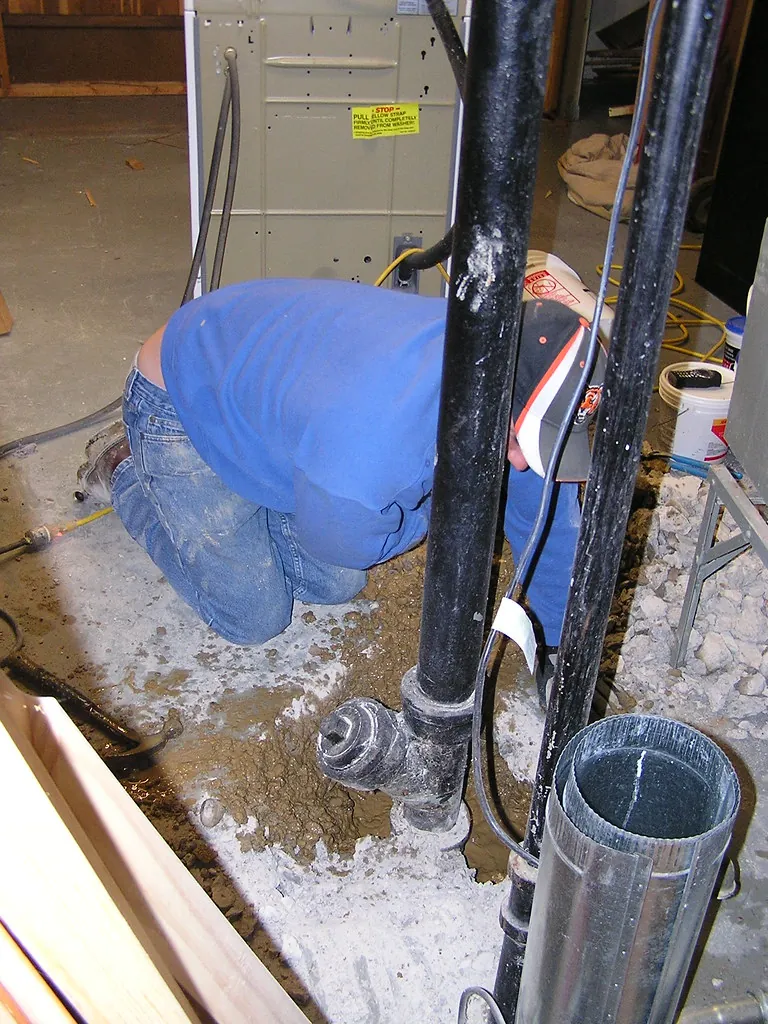 Plumber repairing a pipe during slab leak repair