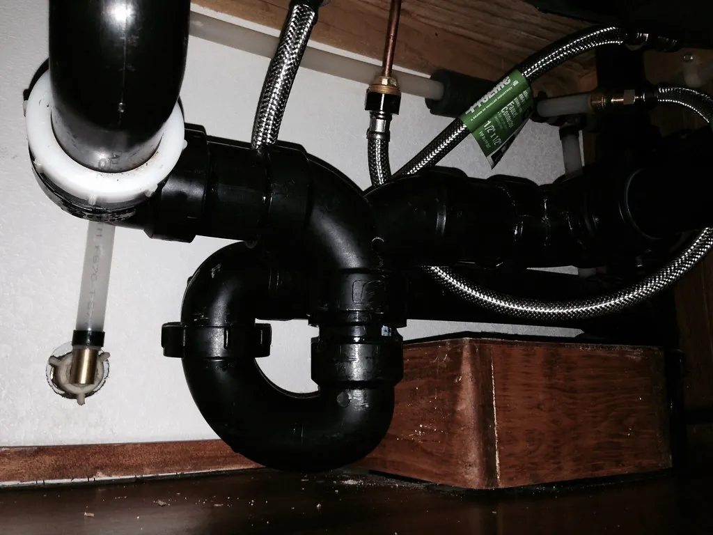 Water leaking from a garbage disposal under a kitchen sink